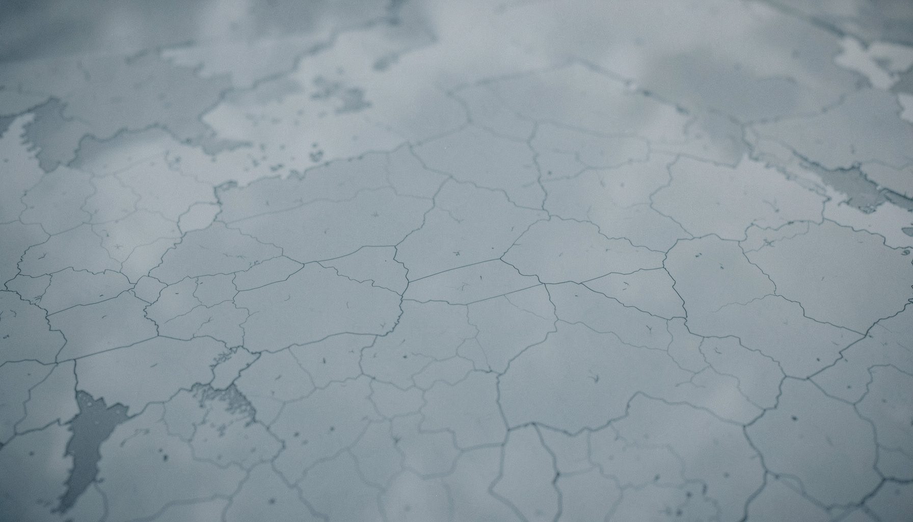 Soft wide aerial-style illustration of a quiet neutral-toned map area in muted blue-gray, understated and calm